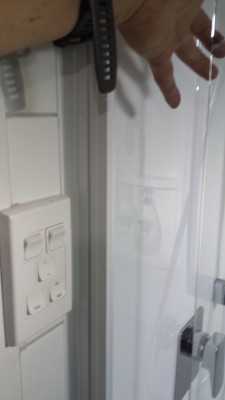 Hand inside shower from outside as door ajar.